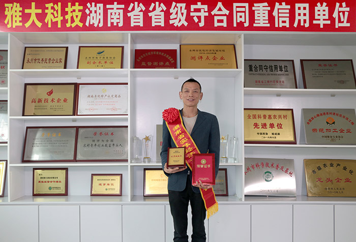 ▲蔣水生在雅大科技榮譽墻前拍照留念